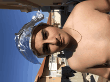 a shirtless boy wearing a tin foil hat on his head