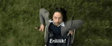 a man in a suit is sitting in a wheelchair and saying eriiiik !