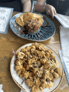 two plates of food are on a wooden table