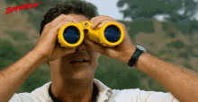 a man looking through a pair of binoculars with the word baywatch on the bottom