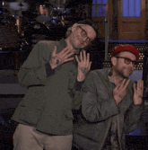 two men are posing for a picture and one has a tattoo on his arm that says no