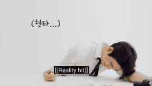 a man in a white shirt and tie is laying on the floor with the words reality hit written below him