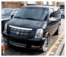 a black cadillac van is parked in front of a home and garden store