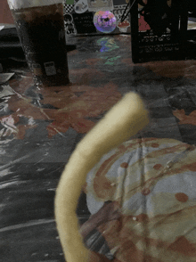 a mcdonald 's cup sits on a table next to a pizza slice