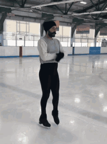 a man with a beard is standing on a ice rink with a sign that says ' ice skating ' on it