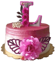 a pink cake with a letter l on top of it