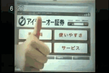 a person 's finger is pointing at a screen that says 6:27 on it