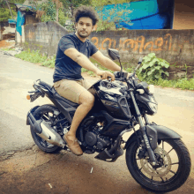 a man sits on a yamaha motorcycle on the side of the road