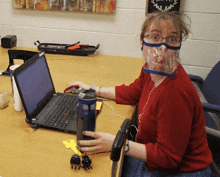 a woman wearing a face mask is using a laptop