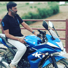 a man is sitting on a blue motorcycle with the letters kt on the front