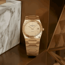 a gold vacheron constantin watch sits on a shelf