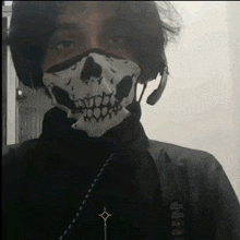 a man wearing a skull mask and a cross necklace