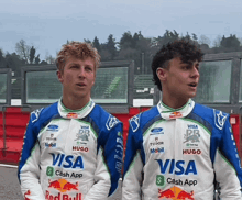 two young men wearing racing suits with visa cash app on them