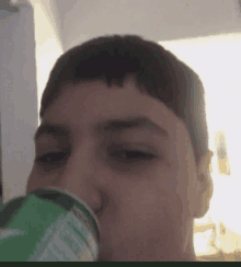 a close up of a person drinking a sprite can