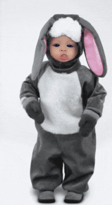 a baby is dressed in a bunny costume with pink and white ears