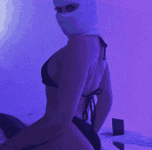 a woman wearing a ski mask and a black bikini