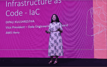 a woman stands in front of a large screen that says infrastructure as code