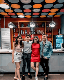 a group of people posing for a picture in front of a bud light cooler