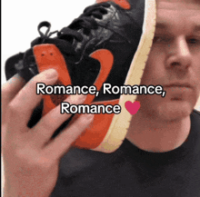 a man is holding a pair of shoes with the words romance romance romance written on the bottom
