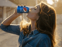 a woman is drinking a can of pepsi soda