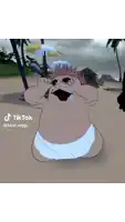 a cartoon character in a diaper is sitting on a beach with an umbrella in the background .