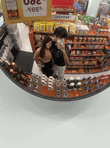a man and a woman are taking a picture in a store with a sign that says " fee "