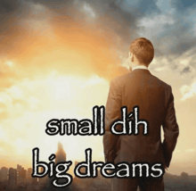 a man in a suit stands in front of a city skyline with the words small dih big dreams written below him