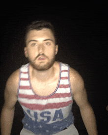 a man with a beard wears a tank top that says usa