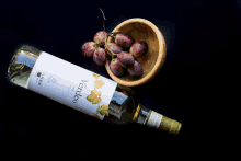 a bottle of verdeo wine is next to a bowl of grapes