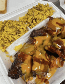 a styrofoam container filled with food including chicken and macaroni and cheese