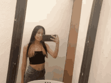 a woman taking a picture of herself in a bathroom mirror