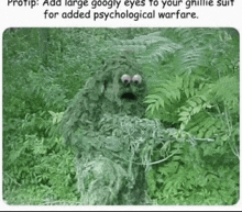 a sesame street character is wearing a ghillie suit and holding a gun in the woods .