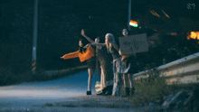 a group of women standing on the side of a road holding a sign that says " we love you "