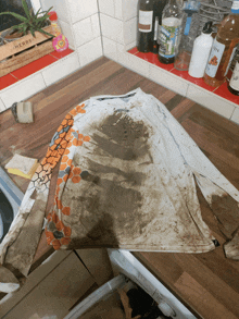 a dirty shirt sits on a wooden counter next to a herb box