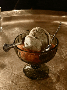 a glass bowl filled with ice cream and a spoon