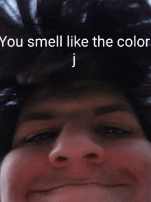 a close up of a person 's face with the words you smell like the color j