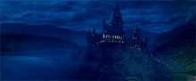 a large castle sits on top of a hill at night