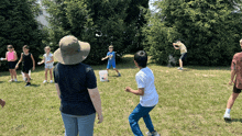 a group of children are playing a game of water balloons in the grass