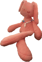 a pink stuffed bunny with a necklace around its neck