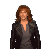 a woman with red hair is wearing a black leather jacket and a grey shirt