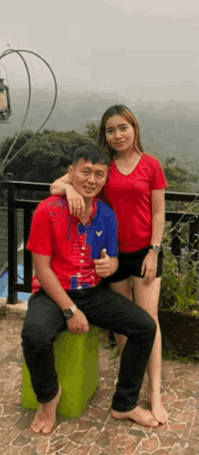 a man in a red shirt is sitting next to a woman