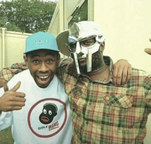 two men are posing for a picture and one has a shirt that says golf wang on it