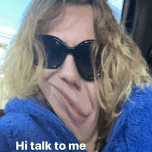 a woman wearing sunglasses and a blue blanket with the words hi talk to me below her face