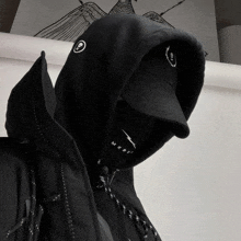 a person wearing a black hoodie and a black hat with the word mxdv on the hood