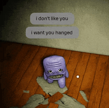 a purple monster is sitting on a wooden floor next to a text that says i don t like you