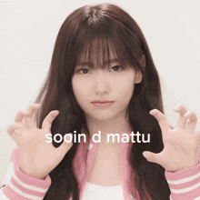 a girl in a pink jacket is making a funny face with the words sooin d matto on the bottom