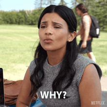 a woman sitting in front of a laptop with the word why written on her shirt