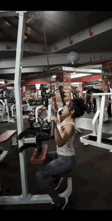 a woman is using a machine in a gym with a sign on the wall that says ' exercise '