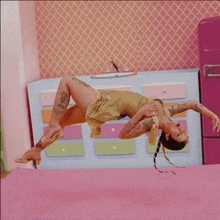 a woman is laying on her back on a pink carpet