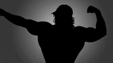 a silhouette of a man flexing his muscles wearing a baseball cap